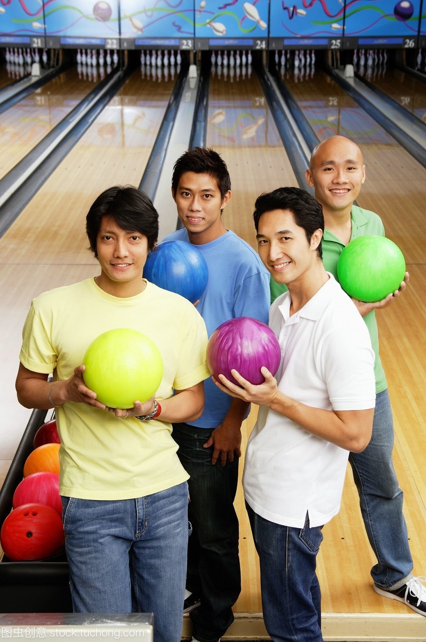 四個人站在保齡球館保齡球球